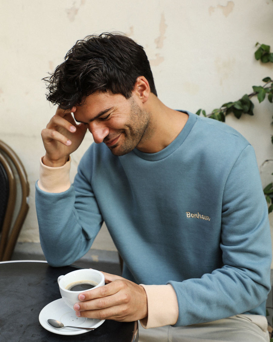homme qui boit un café et porte un sweat en coton